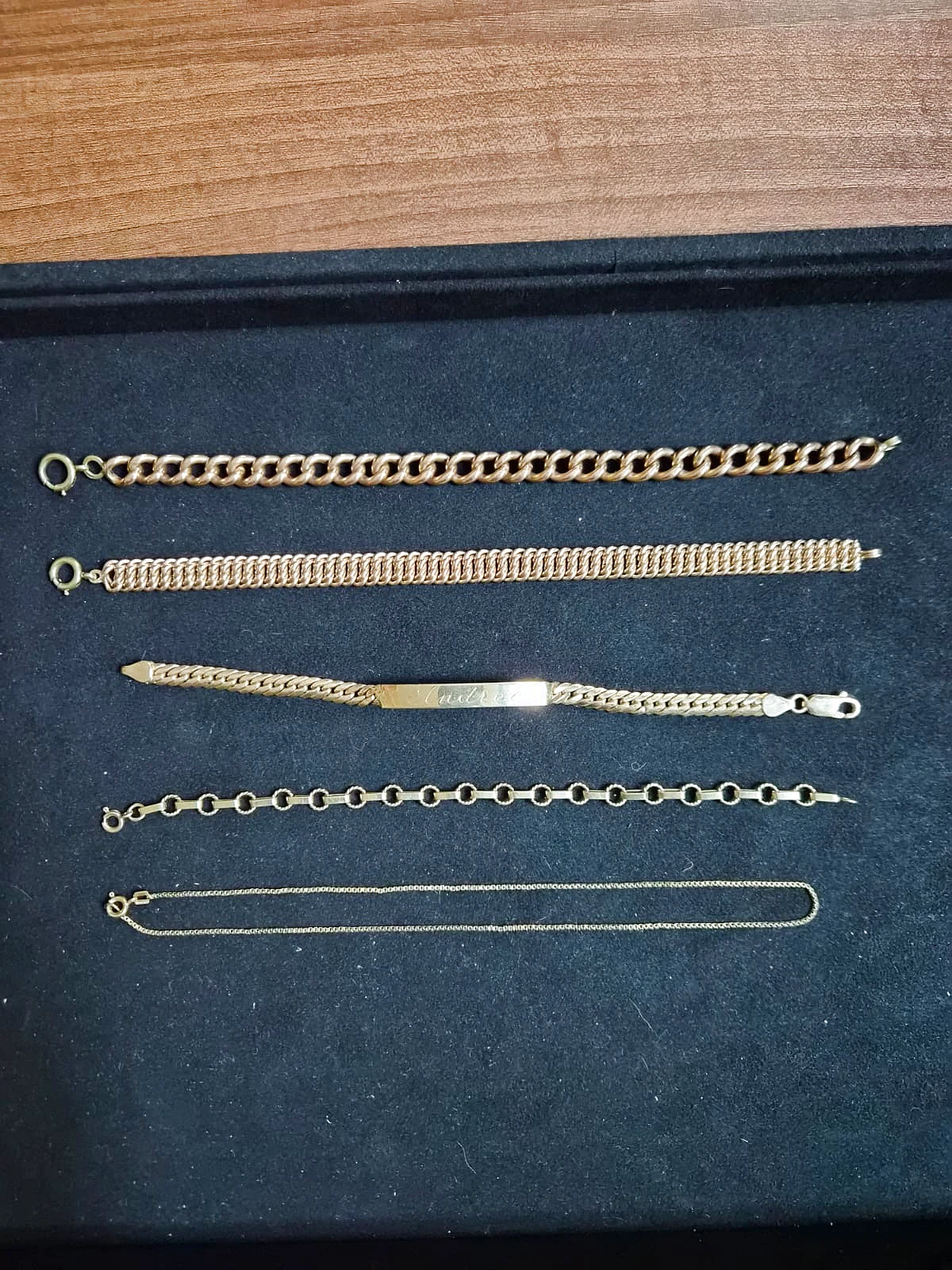 5 massive Goldarmbänder und Halsketten auf schwarzem Samt bei Gold & More Wien